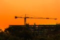 Silhouette tower crane and building on site Industrial construction on sunset background Royalty Free Stock Photo