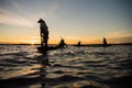 Silhouette of traditional fisherman throwing net fishing lake at Royalty Free Stock Photo