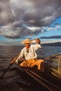 Silhouette of traditional fisherman in wooden boat on Inle lake with fog sunrise , Myanmar