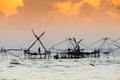 Silhouette of traditional fishing method using a bamboo square dip net with sunrise sky background Royalty Free Stock Photo