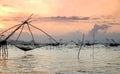 Silhouette of traditional fishing method using a bamboo square dip net with sunrise sky background