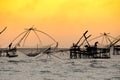 Silhouette of traditional fishing method using a bamboo square dip net with sunrise sky background Royalty Free Stock Photo