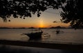 Silhouette of traditional philippines boats on sunset background. Fishing boats in evening dusk with tree silhouette on foreground Royalty Free Stock Photo