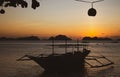 Silhouette of traditional philippines boats on sunset background. Fishing boats in evening dusk with tree silhouette on foreground Royalty Free Stock Photo