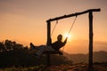Silhouette traveler asian woman sitting with playing wooden swing on mountain at the sunset Royalty Free Stock Photo