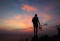 Silhouette of traveler controlling copter and photographing colorful sunrise. Man makes aerial photo and video of sunset sky on be