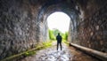 Silhouette traveler man explored in the ancient railway tunnel,