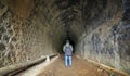 Silhouette traveler man explored in the ancient railway tunnel,