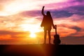 Silhouette traveler women musician holding guitar and her hand while standing on sunset background with copy space. Royalty Free Stock Photo