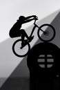 silhouette of trial biker balancing on tractor wheel