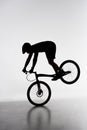 silhouette of trial biker performing front wheel stand Royalty Free Stock Photo