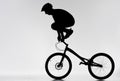 silhouette of trial biker standing on handlebars with hands