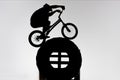 silhouette of trial cyclist balancing on tractor wheel