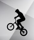 silhouette of trial cyclist jumping on bicycle on abstract grey Royalty Free Stock Photo