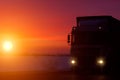 Silhouette Truck with container on highway, cargo transportation concept. Sunset background with copy space