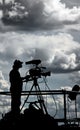 Silhouette of a TV cameraman against cloudy sky Royalty Free Stock Photo