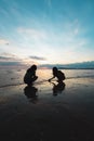 Silhouette of two asian child girls playing on the beach together at the sunset time with beautiful sea and sky. Royalty Free Stock Photo