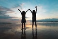 Silhouette of two asian child girls playing on the beach together at the sunset time with beautiful sea and sky. Royalty Free Stock Photo