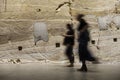 Silhouette of two blurred women walking along sandstone wall in MONA in Hobart, Tasmania, Australia