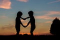 Silhouette of two children, boy brothers, making heart shape wit