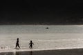 A silhouette of two children playing at the beach