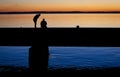 Silhouette of two friends arguing on a concrete bridge with the sunset in the background Royalty Free Stock Photo