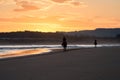 Silhouette of two horse riders on a beach at sunrise. Somo, Spain