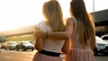 SIlhouette of two hugging girl friends walking on city street at sunset Royalty Free Stock Photo