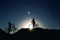 Silhouette of two little girls with bicycles at sunset Royalty Free Stock Photo