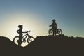 Silhouette of two little girls with bicycles at sunset Royalty Free Stock Photo