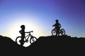 Silhouette of two little girls with bicycles at sunset Royalty Free Stock Photo