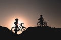 Silhouette of two little girls with bicycles at sunset Royalty Free Stock Photo