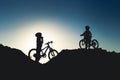 Silhouette of two little girls with bicycles at sunset Royalty Free Stock Photo