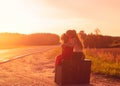 Silhouette of two little girls sitting at vintage suitcase on th