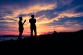 Silhouette two man standing on the clift during sunset