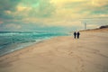 Two men walking on the beach in winter Royalty Free Stock Photo