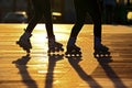 Silhouette of two pairs of legs on roller skates