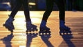 Silhouette of two pairs of legs on roller skates