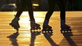 Silhouette of two pairs of legs on roller skates