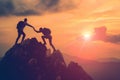 Silhouette two people helping each other hike up a mountain at sunrise or sunset. Giving a helping hand. Travel hiking journey Royalty Free Stock Photo