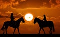 Silhouette of two riders on sunset