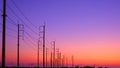 Silhouette two rows of electric poles with cable lines on curve country road against colorful twilight sky background Royalty Free Stock Photo