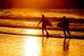 Silhouette of two surfer at yellow sunset Royalty Free Stock Photo