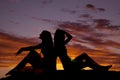 Silhouette two women sit back to back Royalty Free Stock Photo