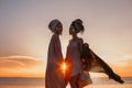 Silhouette of two young beautiful girls in turban on the beach at sunset Royalty Free Stock Photo