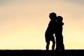 Silhouette of Two Young Children Hugging at Sunset Royalty Free Stock Photo