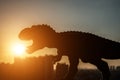 Silhouette of tyrannosaurus and buildings in a sunset time
