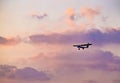 Silhouette of ultralight microlite aircraft flying with a pilot and a passenger against sunset sky Royalty Free Stock Photo