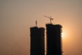 Silhouette of under construction building against sunset with crane on roof showing rapid real estate infrastructure Royalty Free Stock Photo