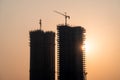 Silhouette of under construction building against sunset with crane on roof showing rapid real estate infrastructure Royalty Free Stock Photo